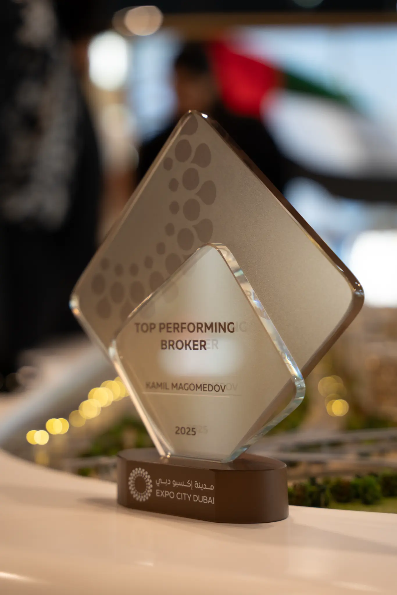 Close-up of the Expo City Dubai Top Performing Broker crystal award engraved with Kamil Magomedov's name, 2025